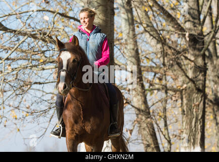 Junges Mädchen reiten durch den Wald Stockfoto