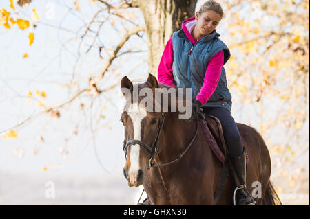 Junges Mädchen reiten durch den Wald Stockfoto