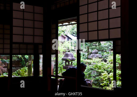 Ein Mann schaut im Hofgarten im Nomura Samurai Haus in Kanazawa, Japan. Stockfoto