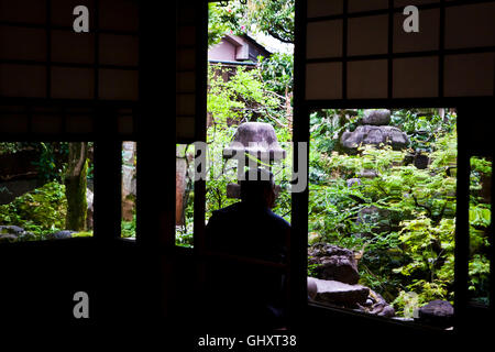 Ein Mann schaut im Hofgarten im Nomura Samurai Haus in Kanazawa, Japan. Stockfoto