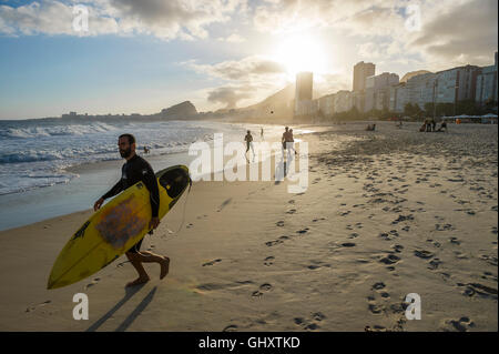 RIO DE JANEIRO - 30. Oktober 2015: Eine brasilianische Surfer Köpfe zum Meer als Gruppe spielt Altinho am Strand der Copacabana. Stockfoto