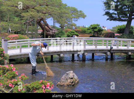 Man reinigt Kenrokuen Garten in Kanazawa Japan, eines der drei großen Gärten Japans. Stockfoto