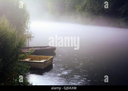 Angelboote/Fischerboote am Fluss Verankerung in der Nähe der Ufer im Nebel. Nebel ist über den Fluss. Stockfoto