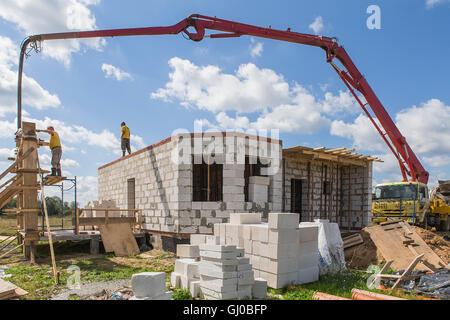 Arbeiter Beton mit einer Betonpumpe mit einem Vibrator gegossen. Stockfoto