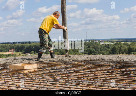 Arbeiter Beton mit einer Betonpumpe mit einem Vibrator gegossen. Stockfoto