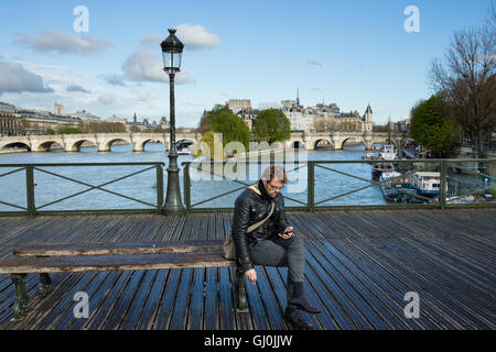 ein Mann auf seinem Handy, der Pont des Arts, Paris, Frankreich Stockfoto