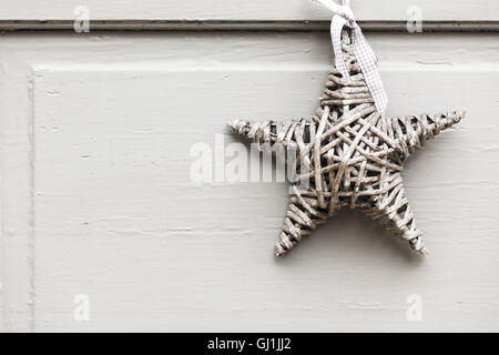 Wicker Sterne hängen weiße Holzwand, Outdoor-Dekoration Hintergrundtextur Foto Stockfoto