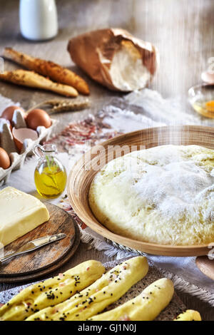 Strömenden Mehl, Hefeteig, rustikale Einrichtung auf einem Holztisch. Stockfoto