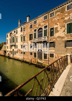 Traditionelle Kanalseite Gebäude mit flockig Rendering und freiliegende Ziegelsteine. Venedig, Italien. Stockfoto