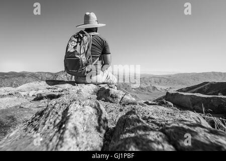 Wanderer, die am Rand einer Klippe Blick auf die Wüste unten Stockfoto