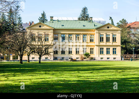 Lund, Schweden - 12. März 2016: Große gelbe Haus im öffentlichen botanischen Garten. Weibliche Person sitzen vor Haus b Stockfoto