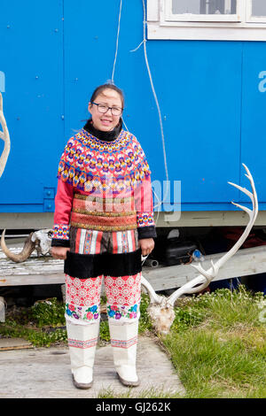 Inuk Mädchen tragen bunte Tracht stehende posiert vor ihrem Haus. Itilleq, Qeqqata, Westgrönland. Stockfoto