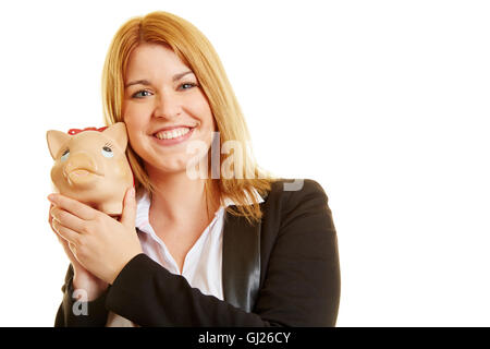 Junge Dame mit einem Sparschwein auf ihren Händen und lächelt Stockfoto