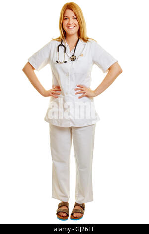 Lächelnde blonde Frau als Arzt oder Krankenschwester mit Hände in die Hüften Stockfoto