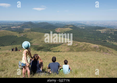 Familien genießen die Aussicht vom Gipfel des Puy de Dome-Vulkans in der Auvergne Südfrankreich saß Stockfoto