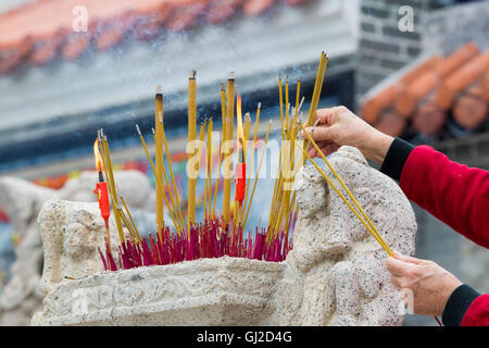 Hände winken Rauchen Räucherstäbchen im Tempel Stockfoto