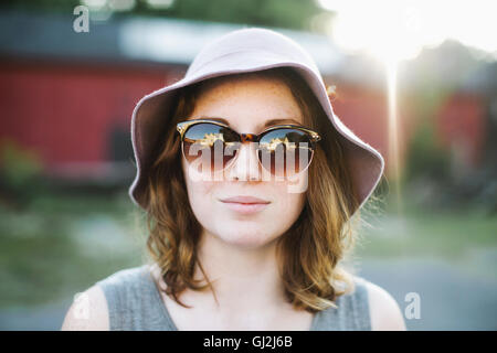 Frau mit Sonnenbrille und Sonnenhut Blick in die Kamera Stockfoto