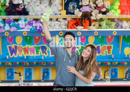Paar vor Festplatz Schießbude mit Teddybär, Coney Island, Brooklyn, New York, USA Stockfoto