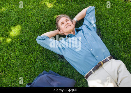 Geschäftsmann entspannend auf Rasen Stockfoto