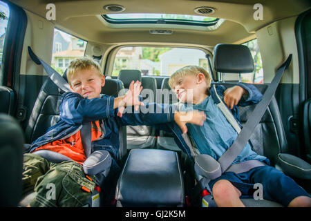 Zwillingsbrüder sitzt auf der Rückseite Fahrzeug, kämpfen Stockfoto