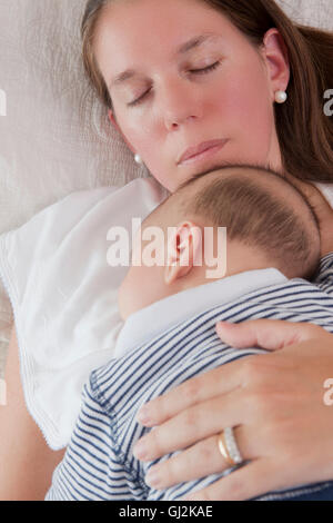 Babyjungen schlafen auf Mütter Brust Stockfoto