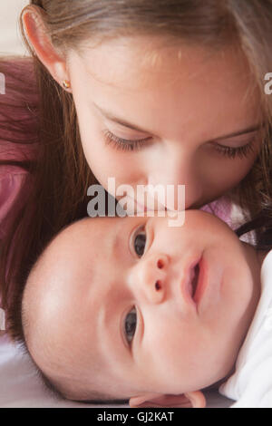 Mädchen küssen Baby junge Stockfoto