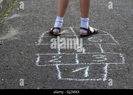 Mädchen spielen Himmel und Hölle Stockfoto