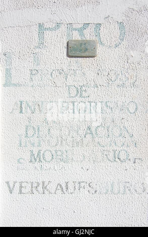 Gedruckte unlegible Wörter in verschiedenen Sprachen auf weißem Putz Wand am 5. August in Port Andratx, Mallorca, Spanien. Stockfoto