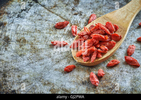 Getrocknete Goji-Beeren in Holzlöffel auf rustikalen metallischen Hintergrund. Textfreiraum Stockfoto