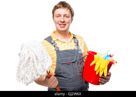 Mann im Overall hält einen Mopp und Reinigungsprodukte auf weißem Hintergrund Stockfoto