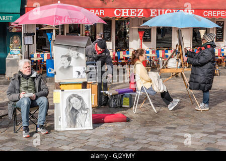 Ein Tourist posiert als ihr Porträt wird von einem Künstler auf dem Montmartre gezeichnet. Stockfoto