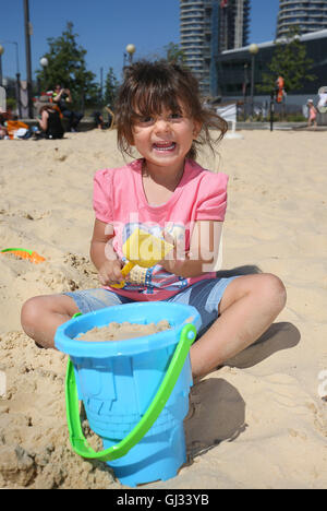 Aylin Lejmi, 3, spielt am Strand von Urban London Beach in den Royal Docks in London. Stockfoto