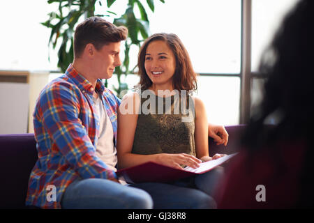 Jungen männlichen Studenten flirten mit weibliche College-Student-lesen-Datei gemeinsam Zimmer Stockfoto