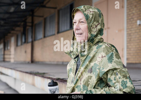 Mann, tragen Camouflage wasserdicht Kapuzenmantel wegschauen Stockfoto