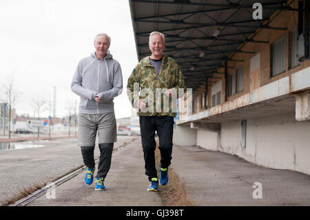 Senioren Freunde tragen Sportkleidung nebeneinander Joggen Stockfoto
