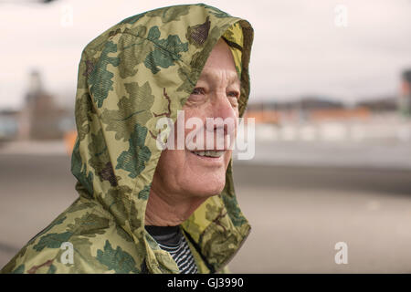 Mann, tragen Camouflage wasserdicht Kapuzenmantel wegschauen Stockfoto