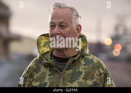 Mann trägt, wasserdicht mit Kapuze Camouflage Mantel wegschauen Stockfoto