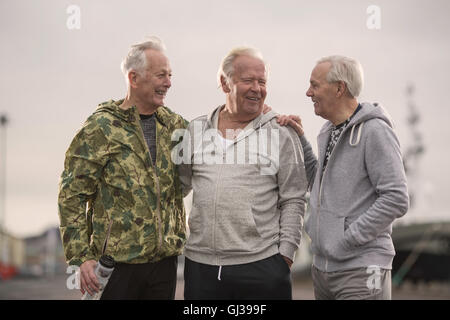 Senioren Freunde Sport Kleidung Arme umeinander Lächeln auf den Lippen tragen Stockfoto