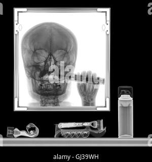 Röntgenbild einer Person Zähneputzen im Badezimmerspiegel Stockfoto