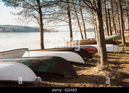 Zeile der umgedrehten Ruderboote am Seeufer, Lahti, Finnland Stockfoto