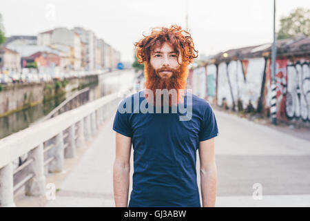 Porträt des jungen männlichen Hipster mit roten Haaren und Bart stehen auf Brücke hautnah Stockfoto