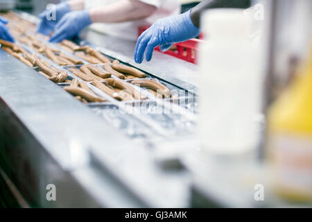 Fabrikarbeiter auf Tofu-Wurst-Produktionslinie Stockfoto