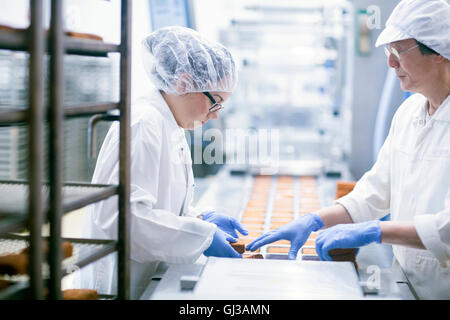 Fabrikarbeiter auf Lebensmittelproduktionlinie Stockfoto