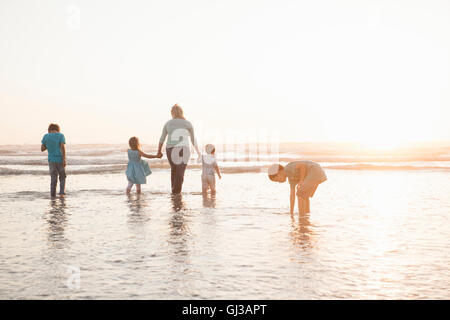 Familie Hand in Hand Paddeln im Ozean Stockfoto