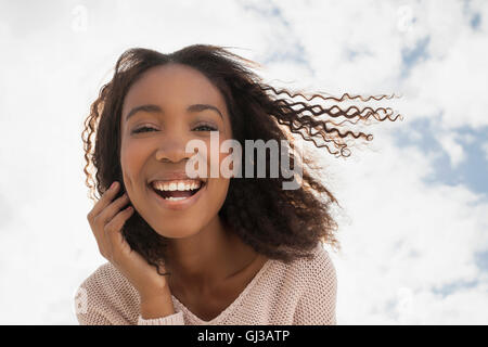 Glückliche junge Frau an windigen Tag Stockfoto