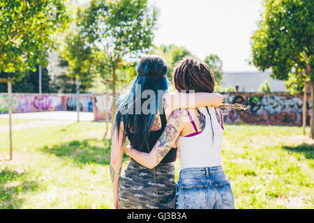 Rückansicht der beiden jungen Frauen in städtischen park Stockfoto