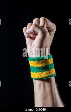 Nahaufnahme des brasilianischen Athleten tragen Brasilien Farben Armband Stanzen die Luft vor schwarzem Hintergrund Stockfoto