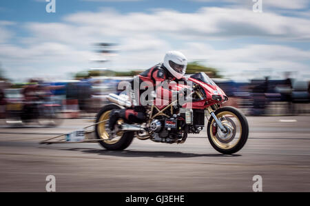 Ein speziell dafür gebauten Drag Bike zeigt seine extreme Beschleunigung, wie es auf der Linie gestartet wird. Stockfoto