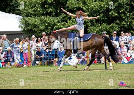 Massen-Uhr lächelndes Mädchen darstellende Akrobatik auf Rückseite galoppierenden Pferd Galloping Akrobatik Countryfile Live Blenheim UK Stockfoto