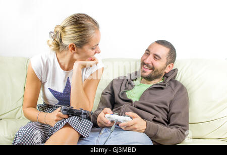 Spaß paar schauen einander an, wie sie Videospiele auf der Couch spielen Stockfoto